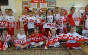 Usmiechniete dzieci z gr. V w bialo-czerwonych strojach.