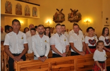Mezczyzni i kobiety z delegacji wiencowej ze Zdzenic stopja w kosciele w trakcie mszy