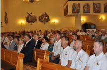 Wierni siedza w trakcie mszy dozynkowej w kosciele