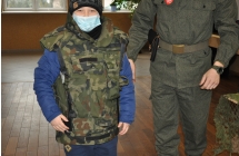 zadowolony chlopiec ubrany w kamizelke wojskowa