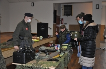 rodzina ogladajaca przedmioty militarne - helm i kamizelki