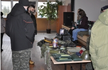 mezczyzni zaciekawieni stoiskiem militarnym