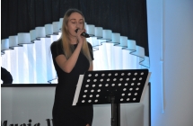 Blondwlosa wokalistka spiewa do mikrofonu trzymanego w dloni