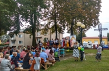 Widzowie siedza przed scena na ktorej stoi grupka dzieci