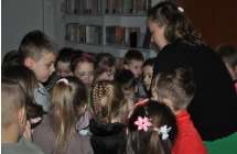 Przedszkolaki stojace wokol kobiety