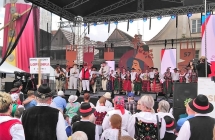 Zespół ludowy na scenie. Dookoła sceny licznie zebrana publiczność 