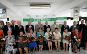 duza grupa osob stoi na tle scianki z napismi