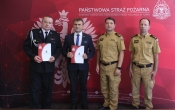 4 mezczyzn stoi na tle czerwonej sciany