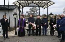 Kilkoro mężczyzn stojących na cmentarzu 