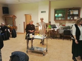 Dwie kobiety przy torcie na sali okolicznościowej 