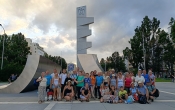 Grupa kilkunastu osób stojących przed pomnikiem 