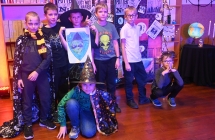 Jedna z drużyn na tle regałów z magicznymi przedmiotami 