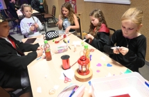 Jedna z drużyn Nocy Bibliotek - siedzą przy stoliku i wykonują magiczne gadżety 