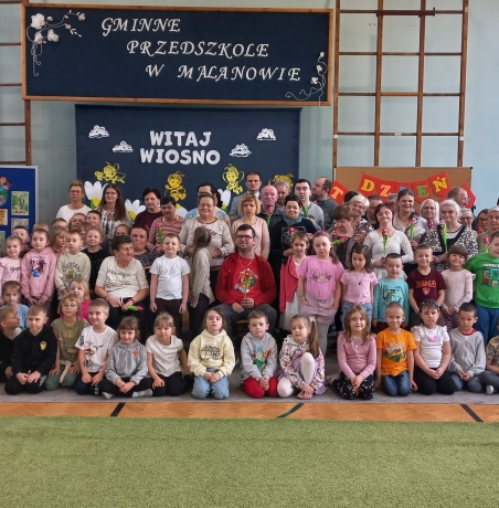 Zdjecie grupowe na tle dekoracji.