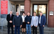 grupa osob stojaca przed budynkiem urzedu gminy