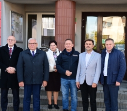 grupa osob stojaca przed budynkiem urzedu gminy
